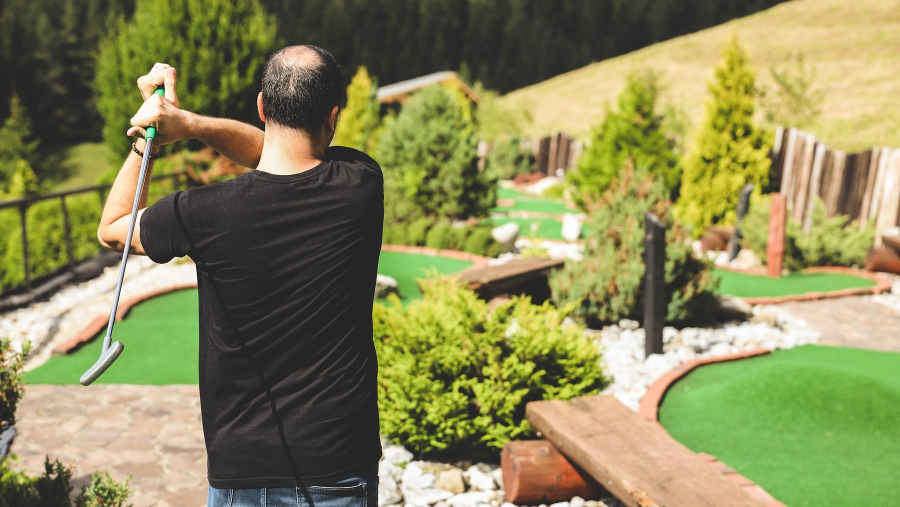 man in black t-shirt standing near swimming pool during daytime