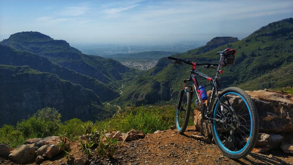 blue and black mountain bike on brown dirt road during daytime